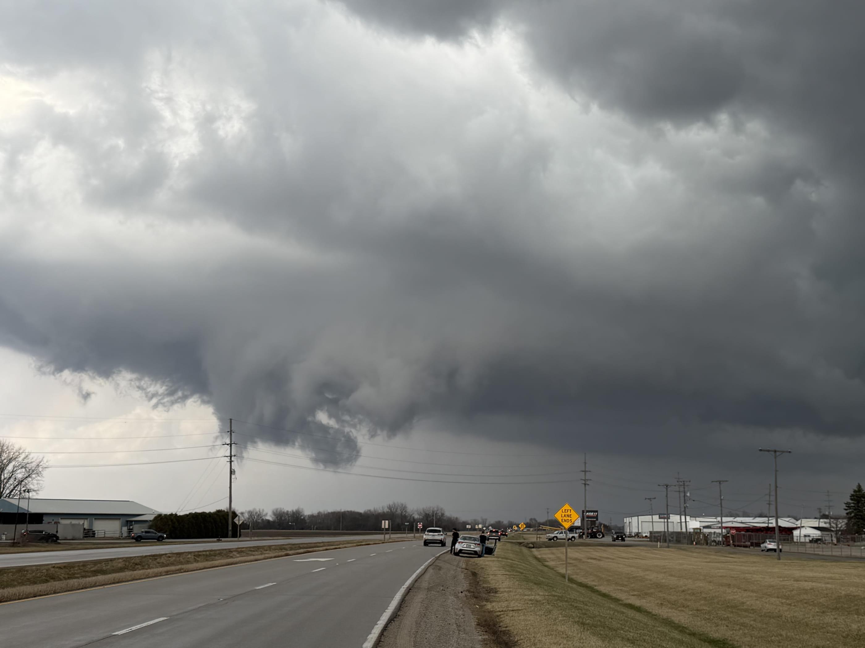 A lowering and rain shaft ahead of traffic on a divided highway at the edge of town.